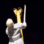 Still image from video showing a hooded man in a white boiler suit painting red paint over a Swansea speed camera lens with a brush on a stick.