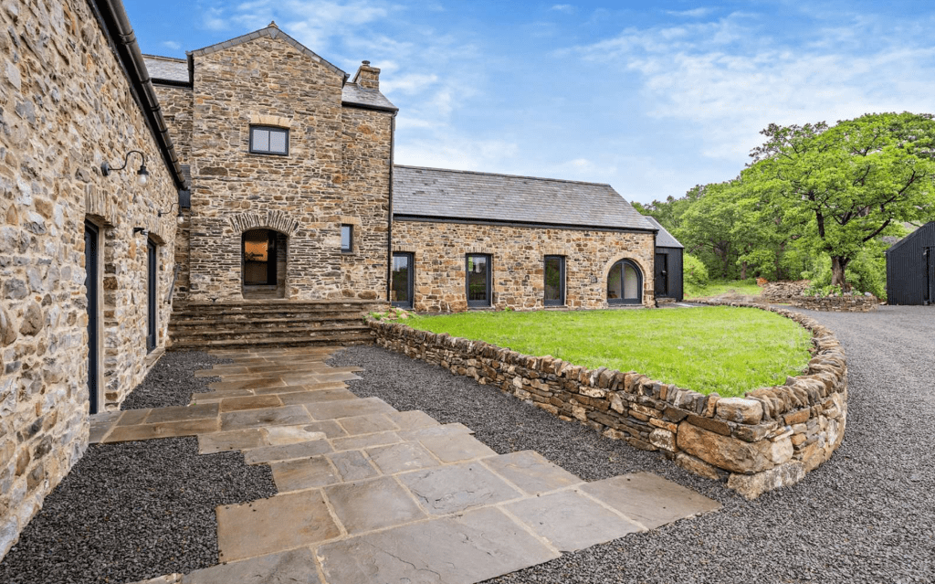 Stone farmhouse with slate roof and surrounding fields