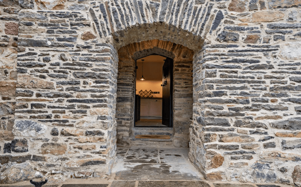 Arched stone entrance leading to modern kitchen