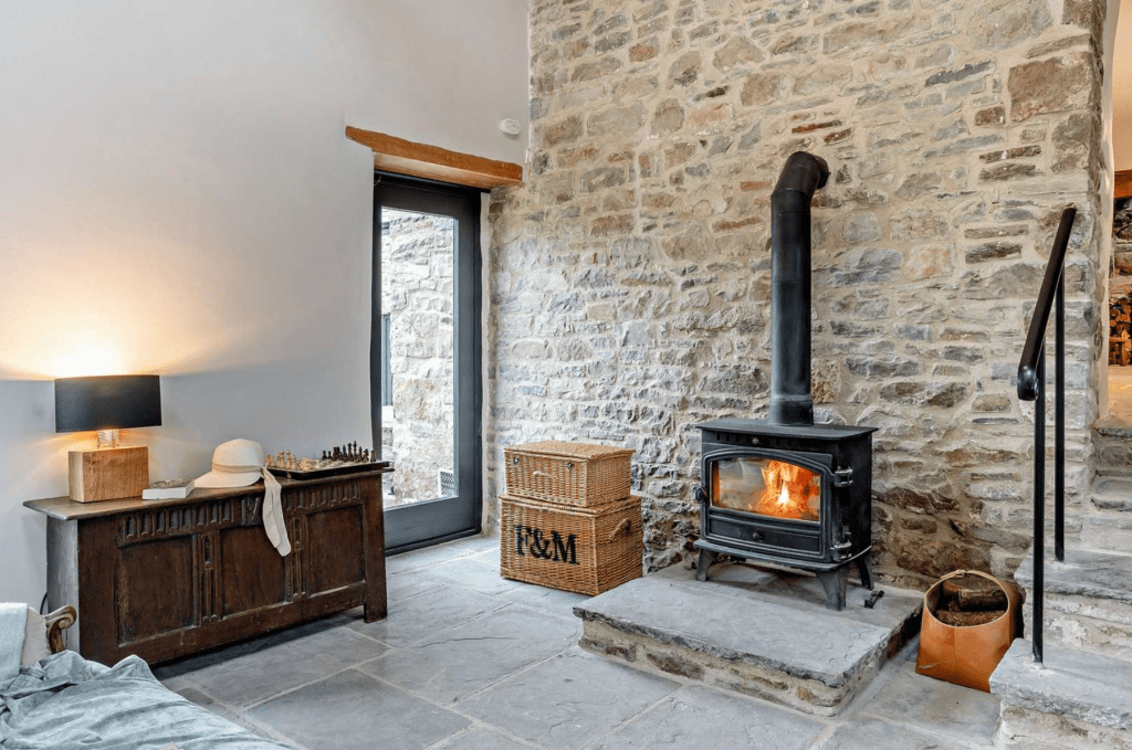 Stone-walled lounge with wood-burning stove and staircase