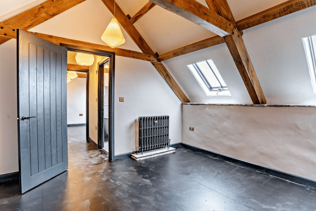 Loft bedroom with skylights and exposed beams