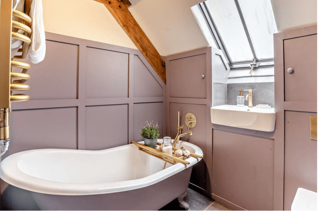 Lavender bathroom with clawfoot tub and brass fittings