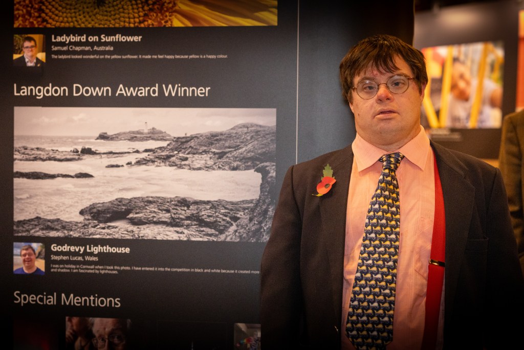 Stephen Lucas standing beside his winning photo Godrevy Lighthouse.