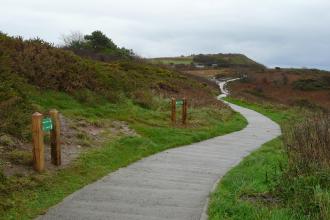 Upgraded Gower coast path showing a wide concrete section between Rotherslade and Limeslade, designed for easier access.