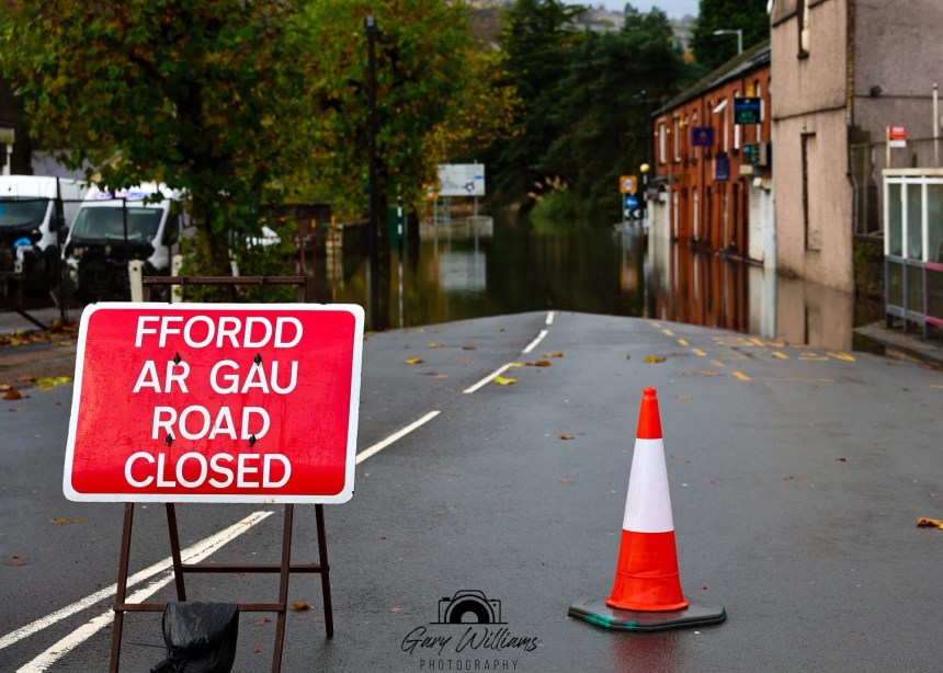 Road closed sign on Approach Road in Swansea with floodwater visible ahead at Cwmbwrla roundabout.