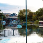 Vehicles almost completely covered by floodwater at Cwmbwrla roundabout in Swansea, with The Gatehouse pub located just above the junction on Carmarthen Road.
