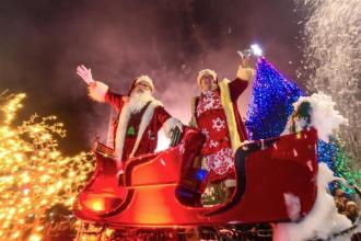Santa and Mrs Claus waving from a sleigh at Swansea Christmas Parade, part of the city’s annual festive events.