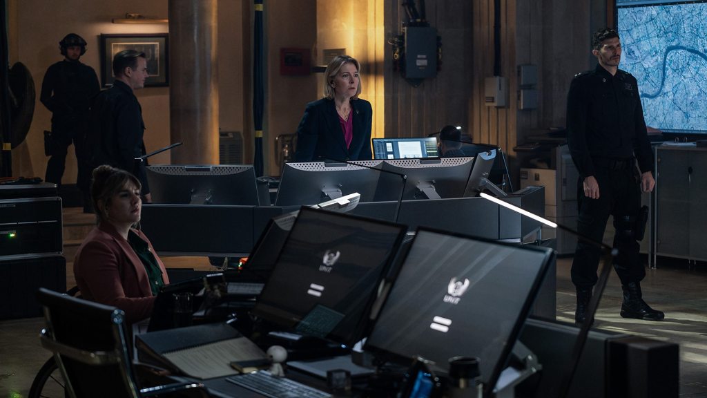 UNIT command centre with personnel at computer stations and a large tactical map on screen.