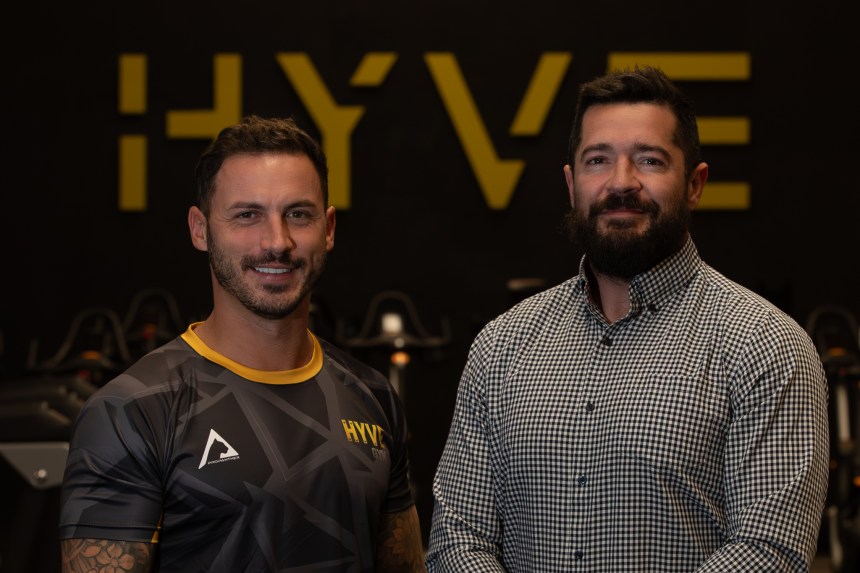 Ioan Jones and Greg George stand in front of HYVE branding after £500k gym acquisition in Carmarthenshire.