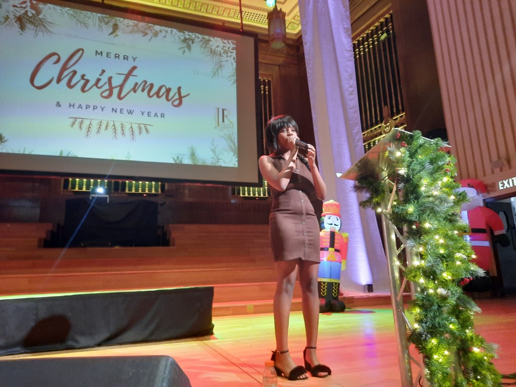 Stage at Brangwyn Hall with Christmas decorations, inflatable Santa and community speakers during Together at Christmas.