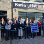 David Chadwick stands with local residents and campaigners outside the new Ystradgynlais Banking Hub during its ribbon‑cutting ceremony.