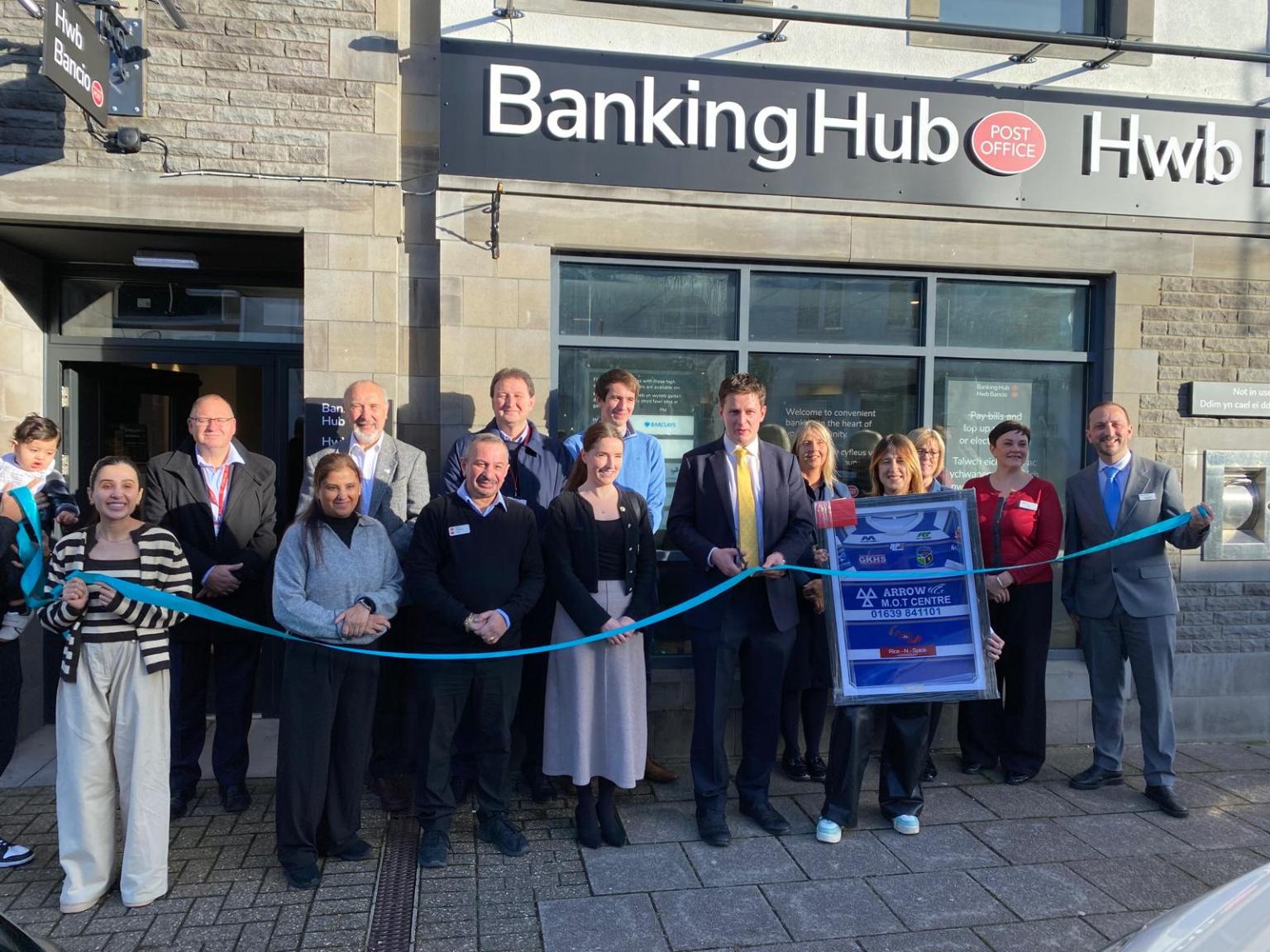 David Chadwick stands with local residents and campaigners outside the new Ystradgynlais Banking Hub during its ribbon‑cutting ceremony.