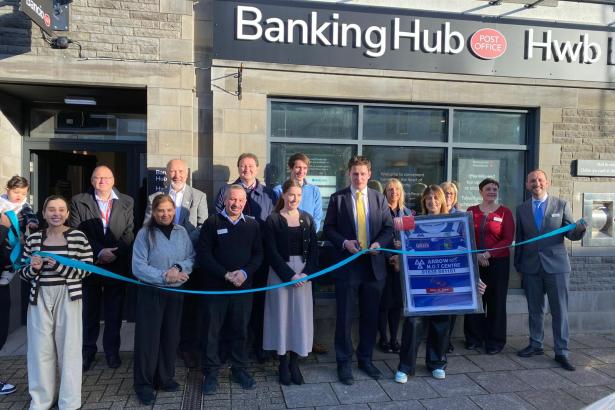 David Chadwick stands with local residents and campaigners outside the new Ystradgynlais Banking Hub during its ribbon‑cutting ceremony.