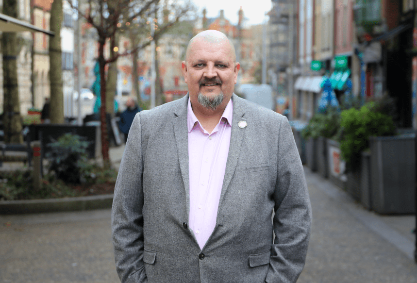 Andrew Douglas standing on Swansea’s Wind Street, with hospitality venues visible behind him.