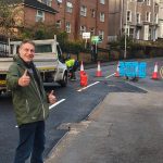Cllr Peter May standing with thumbs up in front of repaired Brynymor Road in Swansea.