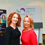 Amy Seppman and Cherrie Bija smiling at a Swansea Bay Business Club event with Help to Grow and sponsor banners.
