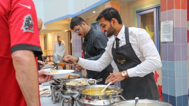 Rasoi chefs serving Indian food to attendees at a Swansea homelessness support event.