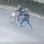 Surveillance still showing a plain‑clothes officer intercepting a cyclist during a shoplifting arrest in Swansea.