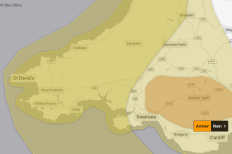 Met Office map highlighting yellow and amber rain warnings across South West Wales, with towns and roads labelled.
