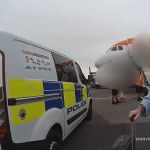 Police van and officers at airport as Lisa Regan is arrested near an EasyJet plane.