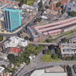 Aerial image of Swansea’s Strand area with railway station, car park, and student towers.