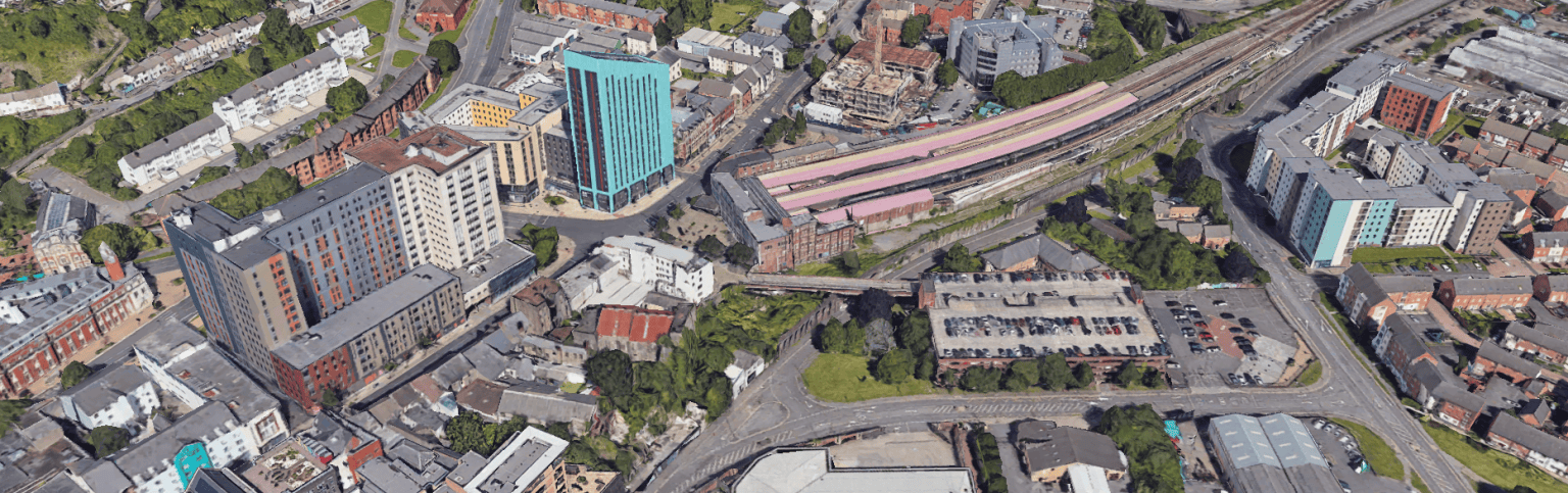 Aerial image of Swansea’s Strand area with railway station, car park, and student towers.