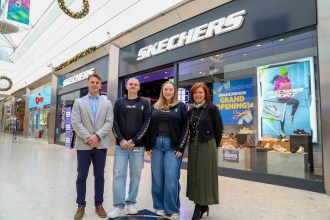 Four people standing in front of Skechers store at Swansea’s Quadrant Shopping Centre during grand opening.