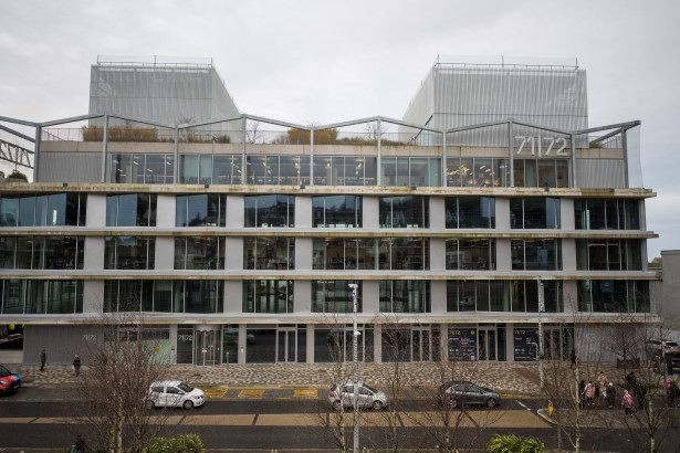 Exterior of 71/72 Kingsway building in Swansea with glass facade and visible signage.