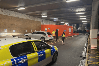Police car and officers carrying out taxi inspection checks in Swansea city centre.