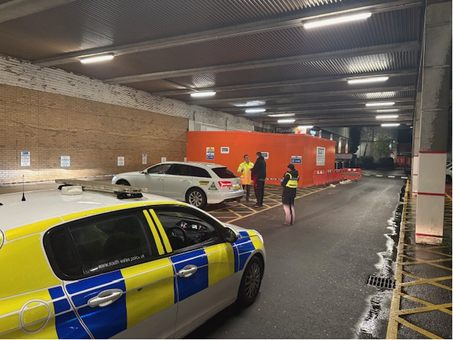 Police car and officers carrying out taxi inspection checks in Swansea city centre.