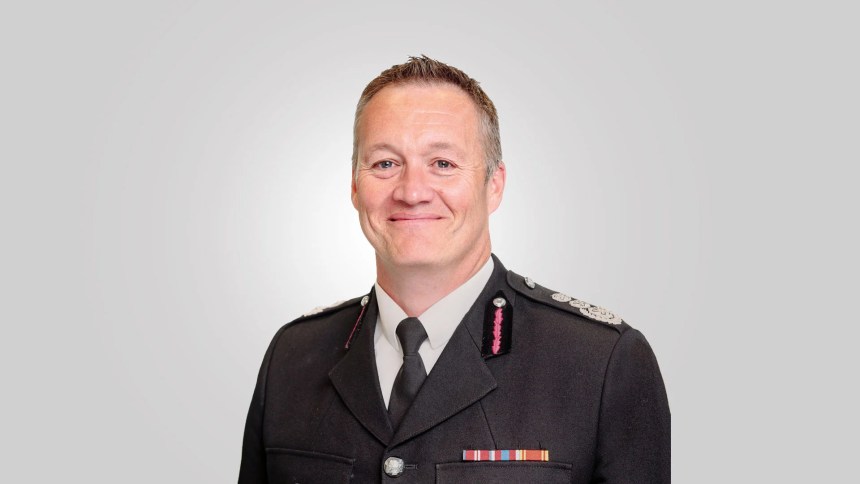 Craig Flannery in fire service uniform with service ribbons, photographed against a plain grey background.