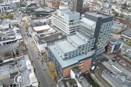 Screenshot from aerial video showing the unfinished Biophilic Living Biome tower under construction in Swansea, with planting and rooftop gardens yet to be installed.