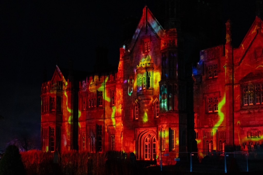 Multicoloured light projections on historic castle façade at night, part of Luminate Wales. Credit: www.clarehardingphotography.com
