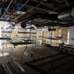 Interior of abandoned M&S store showing exposed ceiling, hanging cables, and metal frames — part of suspected cannabis setup.