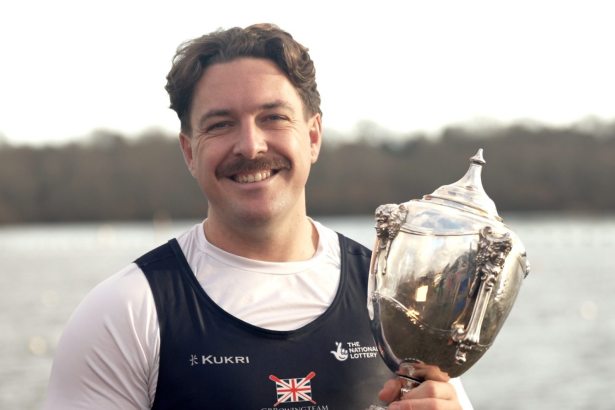 Ben Pritchard holding rowing trophy outdoors after winning European and world titles in 2025.
