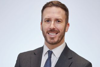 Professional headshot of Paul Kift, Principal of Gower College Swansea, wearing a dark suit and tie.