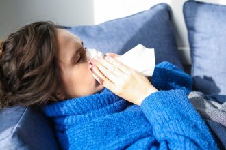 woman in blue sweater lying on bed