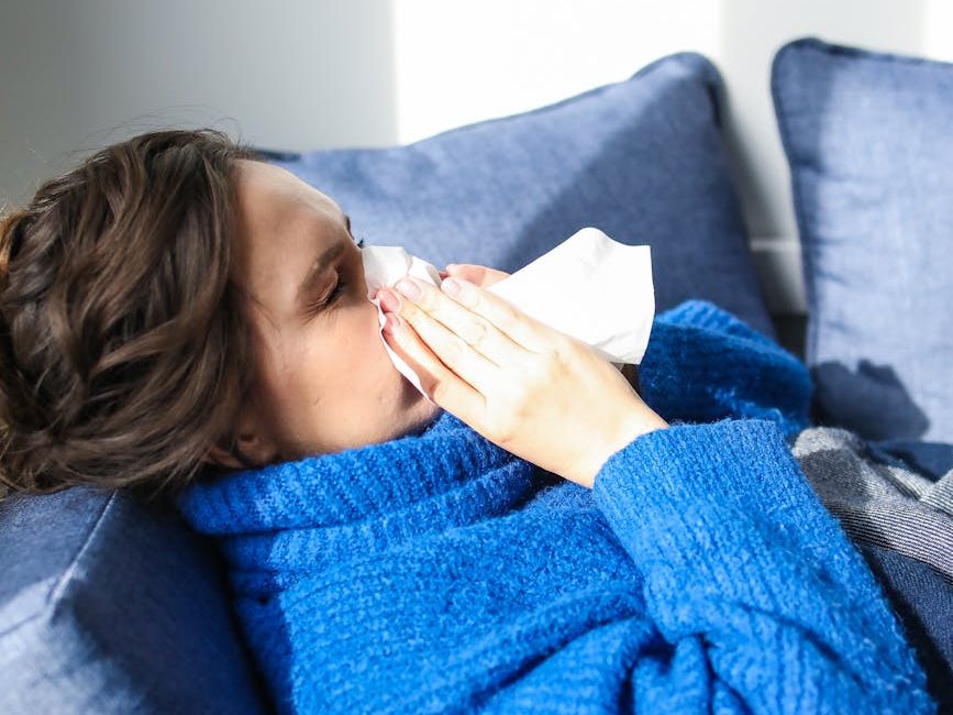 woman in blue sweater lying on bed