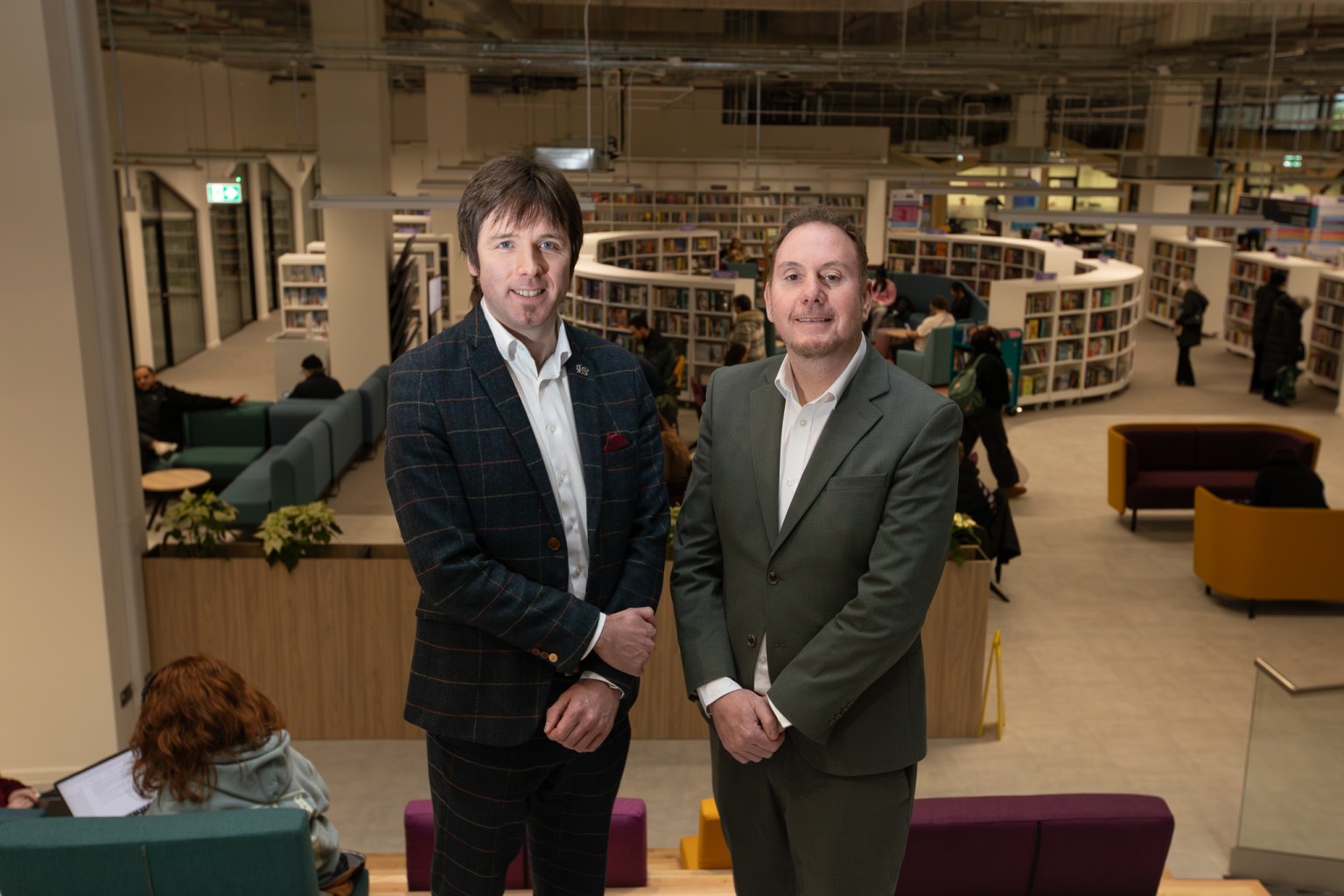 Steve Lemon and Rob Stewart stand inside Y Storfa with the new public library visible in the background.