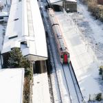 Overhead view of a TfW train at Llanelli station with snow covering the ground.