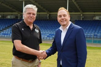 Rob Stewart and Lance Bradley shaking hands on a rugby pitch during discussions about the Ospreys’ future.