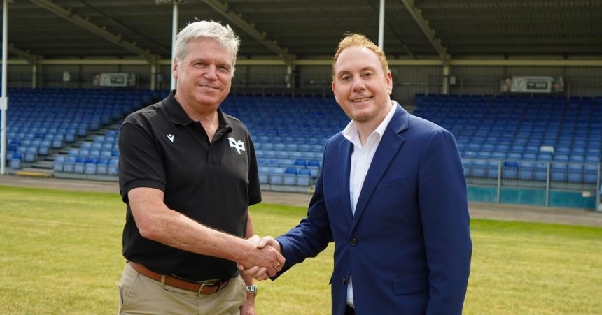 Rob Stewart and Lance Bradley shaking hands on a rugby pitch during discussions about the Ospreys’ future.