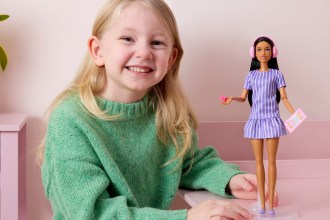 Penelope, aged five, holding the new autistic Barbie doll designed with input from autistic children.
