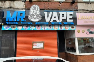 Red‑shuttered vape shop in Port Talbot with an official closure notice attached.