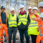 Group of Welsh Government and Neath Port Talbot Council leaders standing at a coal tip site during a visit announcing new safety funding.