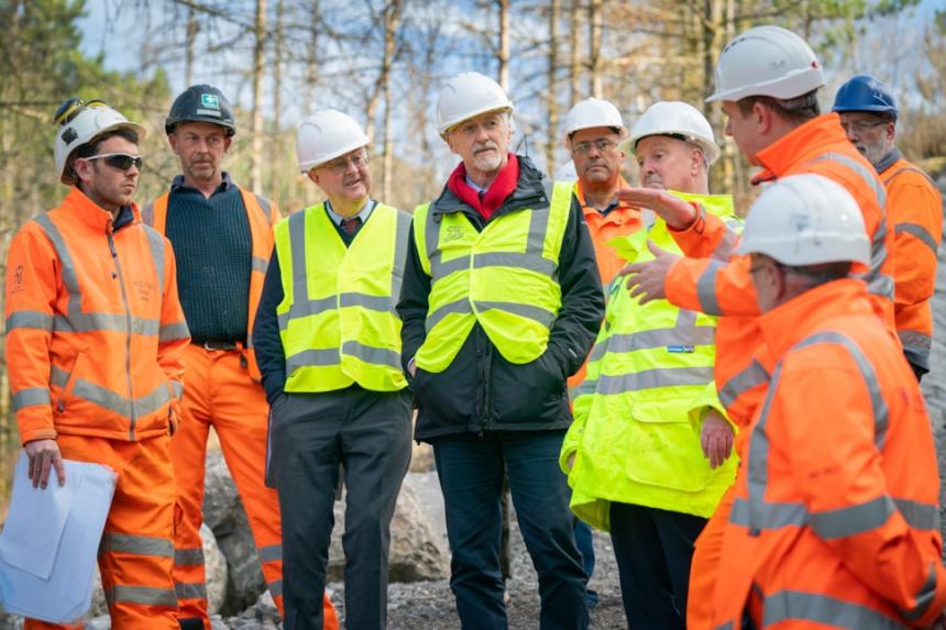 Group of Welsh Government and Neath Port Talbot Council leaders standing at a coal tip site during a visit announcing new safety funding.
