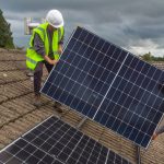 Two CES workers fitting solar panels on a rooftop before the company ceased trading.