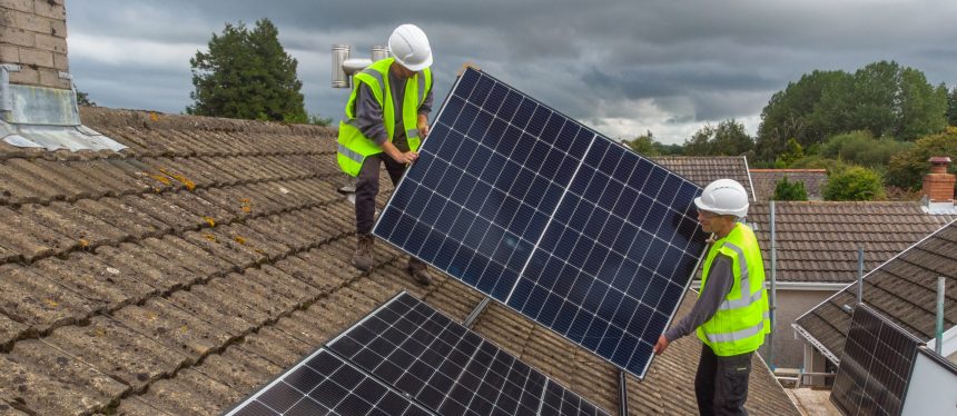 Two CES workers fitting solar panels on a rooftop before the company ceased trading.