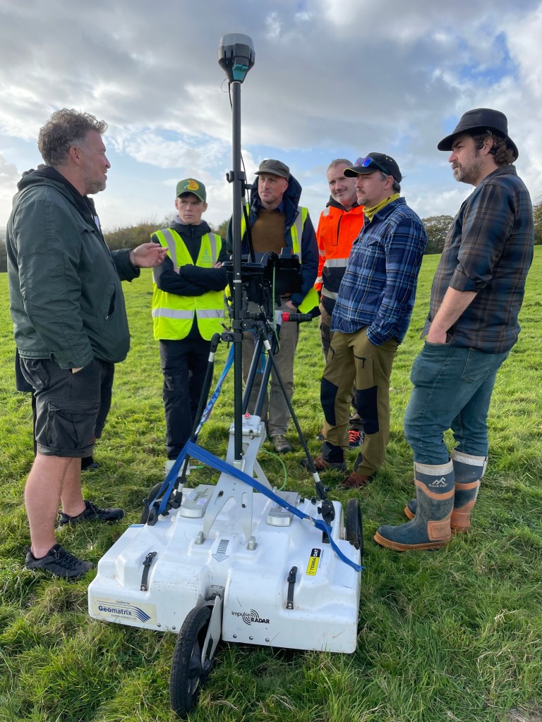 Terradat geophysics team reviewing survey data with equipment at Margam.