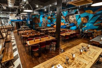 Founders & Co Swansea communal dining area with mural, long tables and relaxed seating.